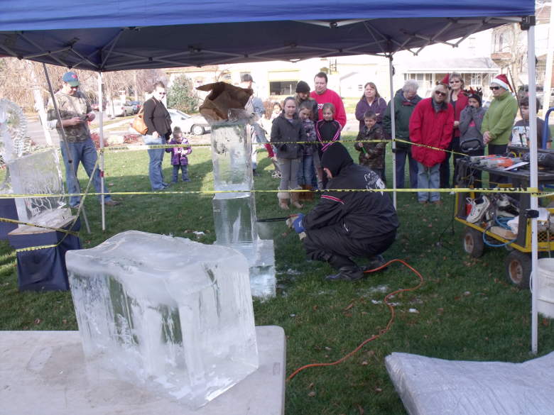 [photo of artist doing ice sculpture with a chainsaw]