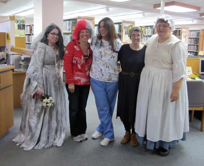 [photo of five library staff members in assorted costumes]