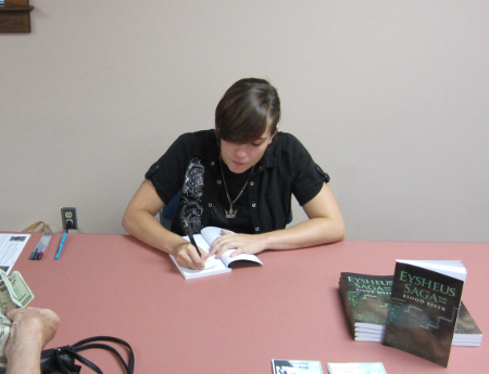 [photo of Esther Mendell signing a copy of her book]