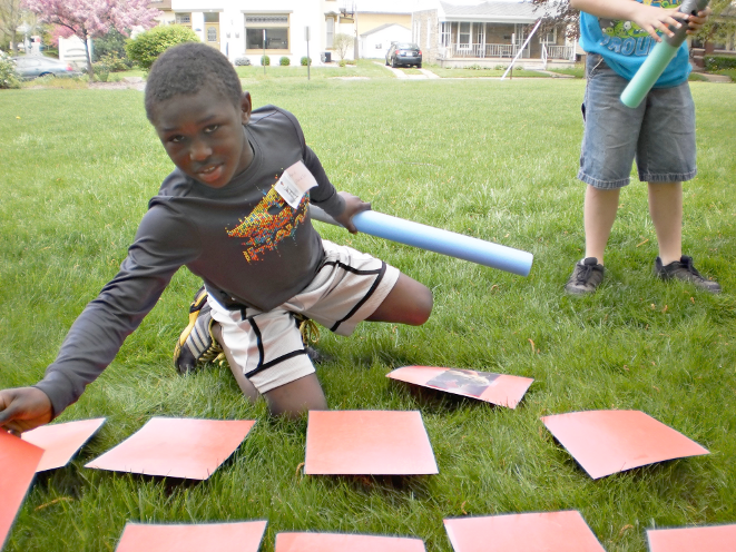 [photo of a boy holding a foam noodle while playing the matching game]