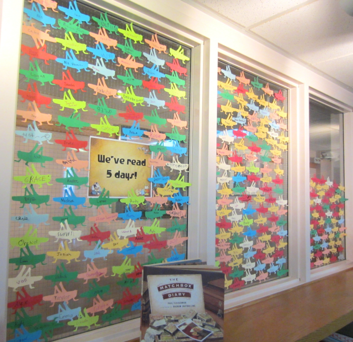 [photo: for each child who read 5 days, a grasshopper outline with the child's name was placed on the windows]