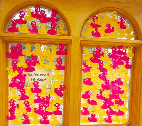 [photo: for each child who read 20 days, a pirate duck outline with the child's name was placed on the windows]